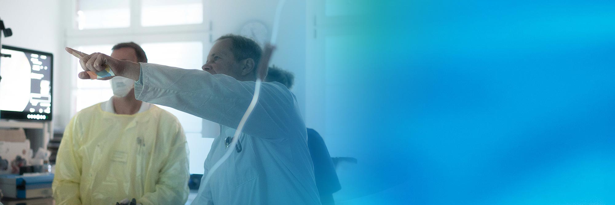 Arzt und Medizinisches Personal bei einer Untersuchung eines Patienten.