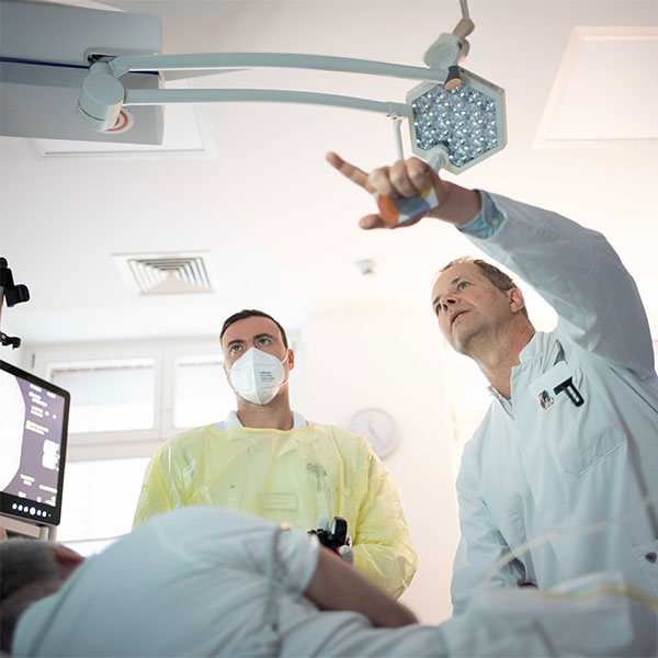 Arzt und medizinisches Fachpersonal bei einer Ultraschalluntersuchung am Patientenbett