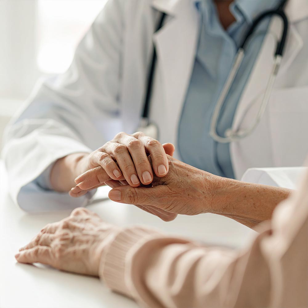 Eine Ergotherapeutin trainiert mit einem Patienten die Feinmotorik der Hände.